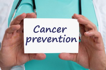 Cancer prevention written on card help by male doctor